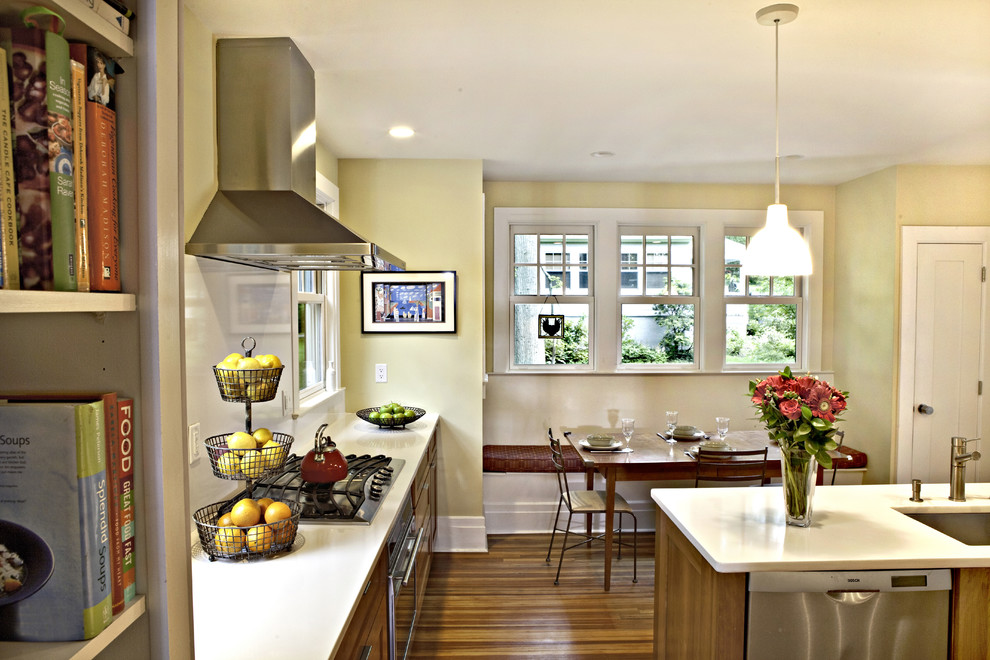 Foto på ett eklektiskt kök, med skåp i mellenmörkt trä, bänkskiva i kvartsit, vitt stänkskydd, rostfria vitvaror och en köksö