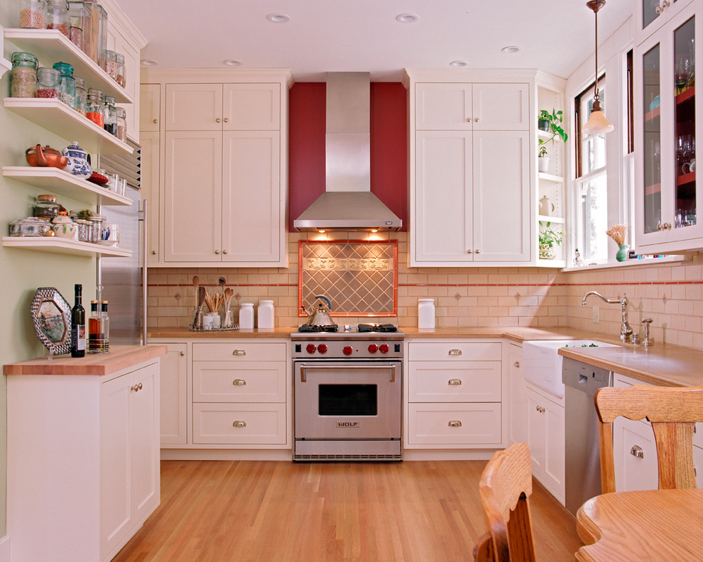 Exempel på ett klassiskt kök, med en rustik diskho, skåp i shakerstil, vita skåp, beige stänkskydd, stänkskydd i tunnelbanekakel och rostfria vitvaror