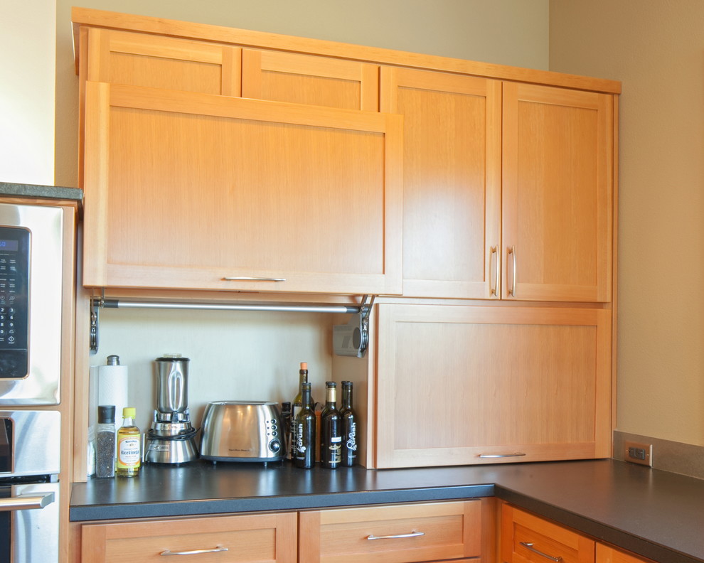 Moderne Küche mit Schrankfronten im Shaker-Stil, hellbraunen Holzschränken, Küchenrückwand in Schwarz, Rückwand aus Stein und Küchengeräten aus Edelstahl in Portland
