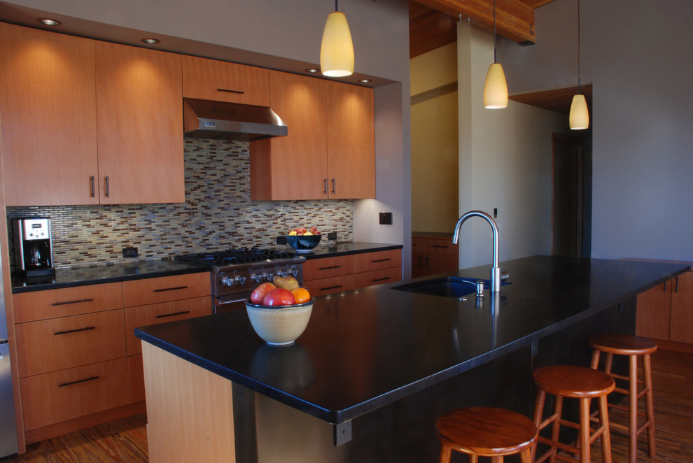Cette photo montre une cuisine moderne en bois brun de taille moyenne avec un placard à porte plane, un plan de travail en granite, une crédence en carreau de ciment, un sol en bois brun et 2 îlots.