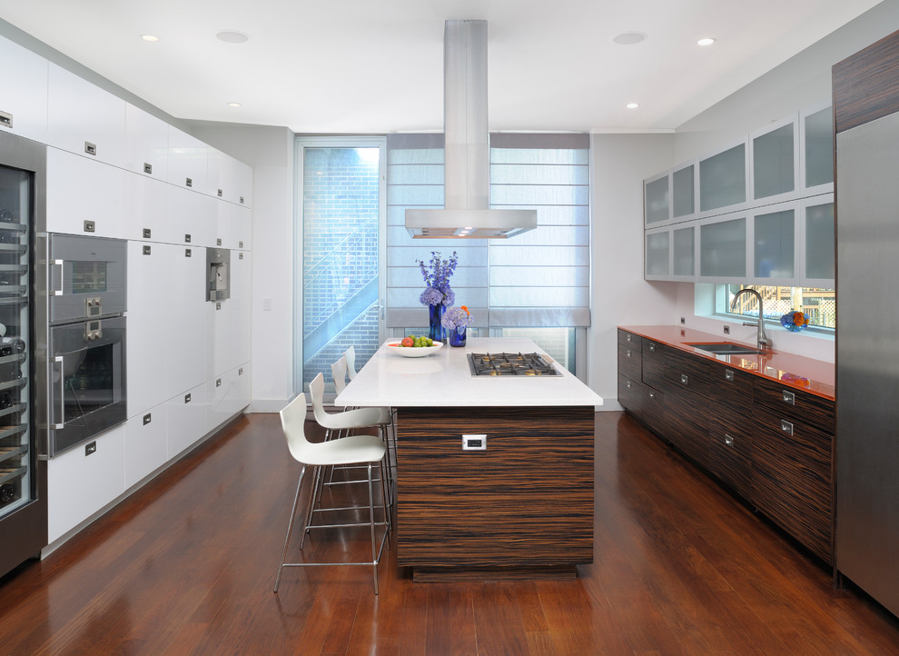 Zweizeilige Moderne Küche mit Unterbauwaschbecken, flächenbündigen Schrankfronten, dunklen Holzschränken, Rückwand-Fenster, Küchengeräten aus Edelstahl, dunklem Holzboden, Kücheninsel, braunem Boden und oranger Arbeitsplatte in Chicago