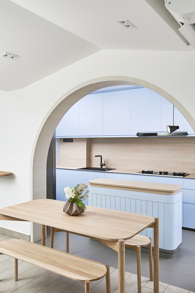 Foto på ett minimalistiskt beige kök och matrum, med en nedsänkt diskho, släta luckor, blå skåp, beige stänkskydd, en köksö och grått golv