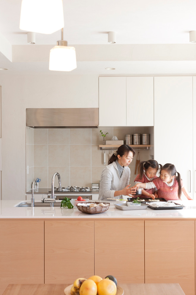 東京23区にある中くらいなおしゃれなキッチン (アンダーカウンターシンク、フラットパネル扉のキャビネット、白いキャビネット、白いキッチンパネル、テラコッタタイルのキッチンパネル、シルバーの調理設備、無垢フローリング) の写真