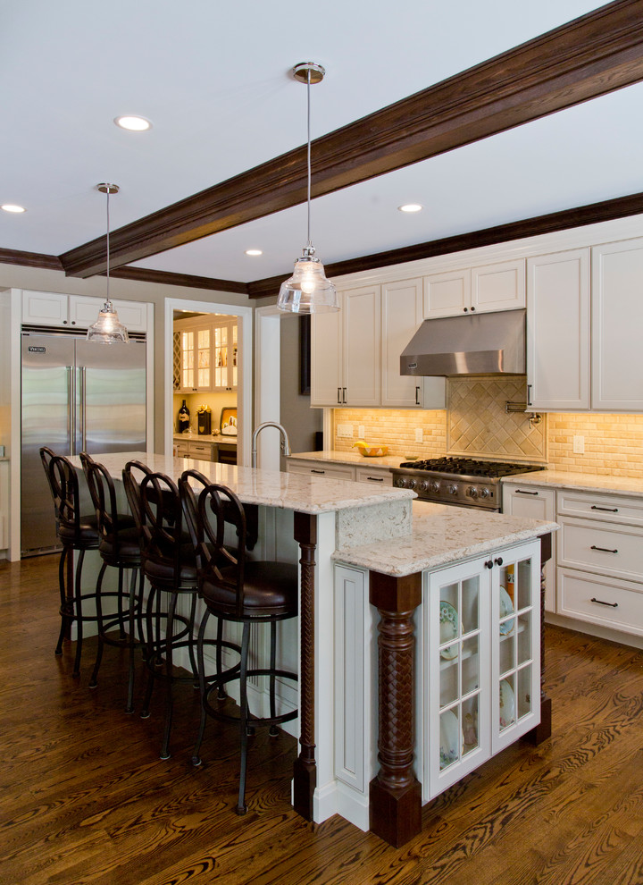 Eat-in kitchen - large traditional l-shaped medium tone wood floor and brown floor eat-in kitchen idea in St Louis with recessed-panel cabinets, light wood cabinets, granite countertops, beige backsplash, stone tile backsplash, stainless steel appliances and an island