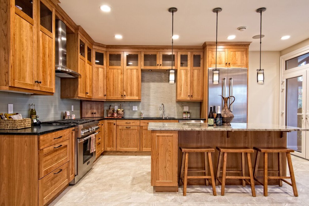 Inspiration for a mid-sized craftsman u-shaped ceramic tile and beige floor eat-in kitchen remodel in New York with a drop-in sink, light wood cabinets, granite countertops, gray backsplash, subway tile backsplash, stainless steel appliances, an island and shaker cabinets