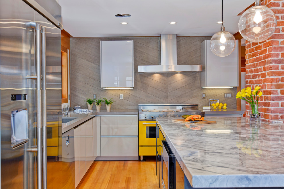Example of a mid-sized trendy l-shaped medium tone wood floor open concept kitchen design in San Diego with an undermount sink, flat-panel cabinets, gray cabinets, quartz countertops, gray backsplash, porcelain backsplash, colored appliances and an island