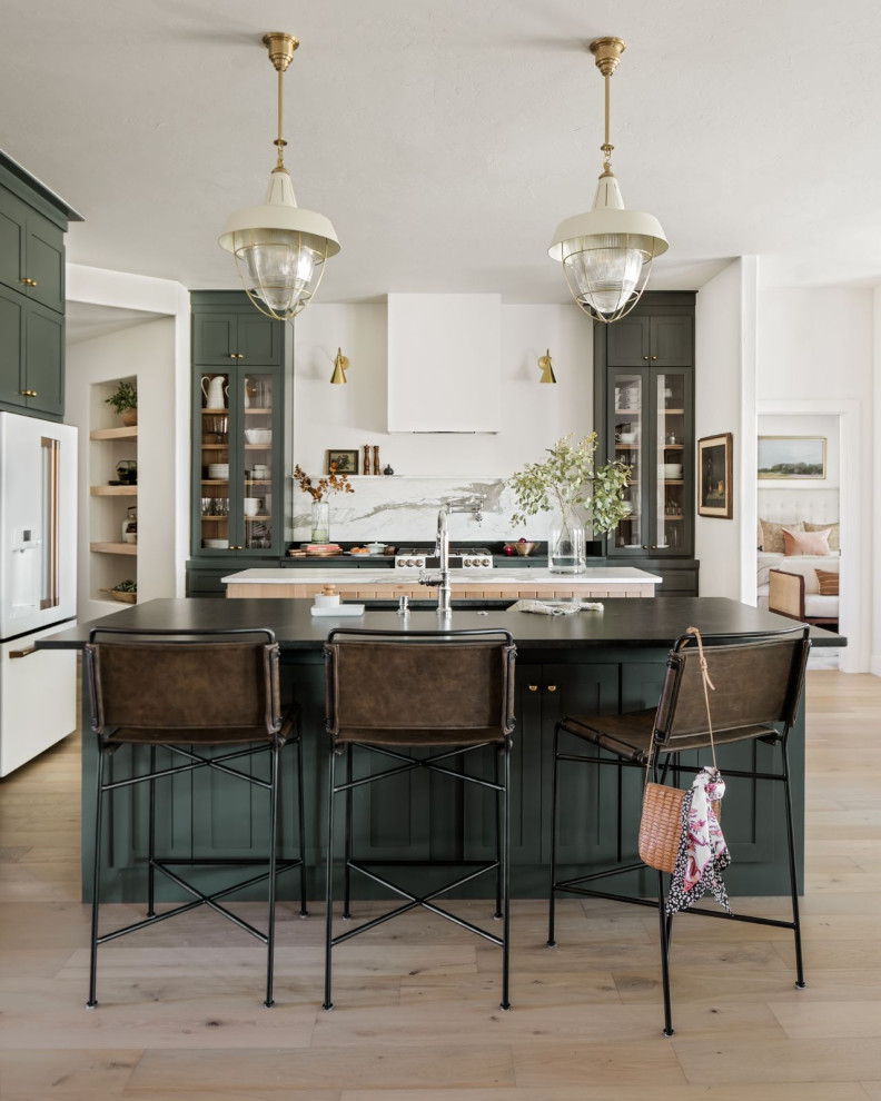 Inspiration pour une grande cuisine ouverte traditionnelle en L avec un évier encastré, un placard à porte shaker, des portes de placards vertess, un plan de travail en quartz, une crédence blanche, une crédence en marbre, un électroménager blanc, parquet clair, 2 îlots, un sol marron et plan de travail noir.