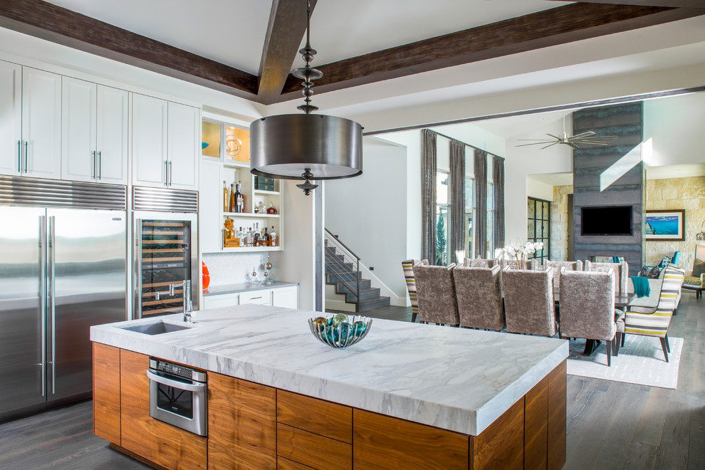 Example of a trendy dark wood floor open concept kitchen design in Austin with an undermount sink, shaker cabinets, white cabinets, stainless steel appliances and an island