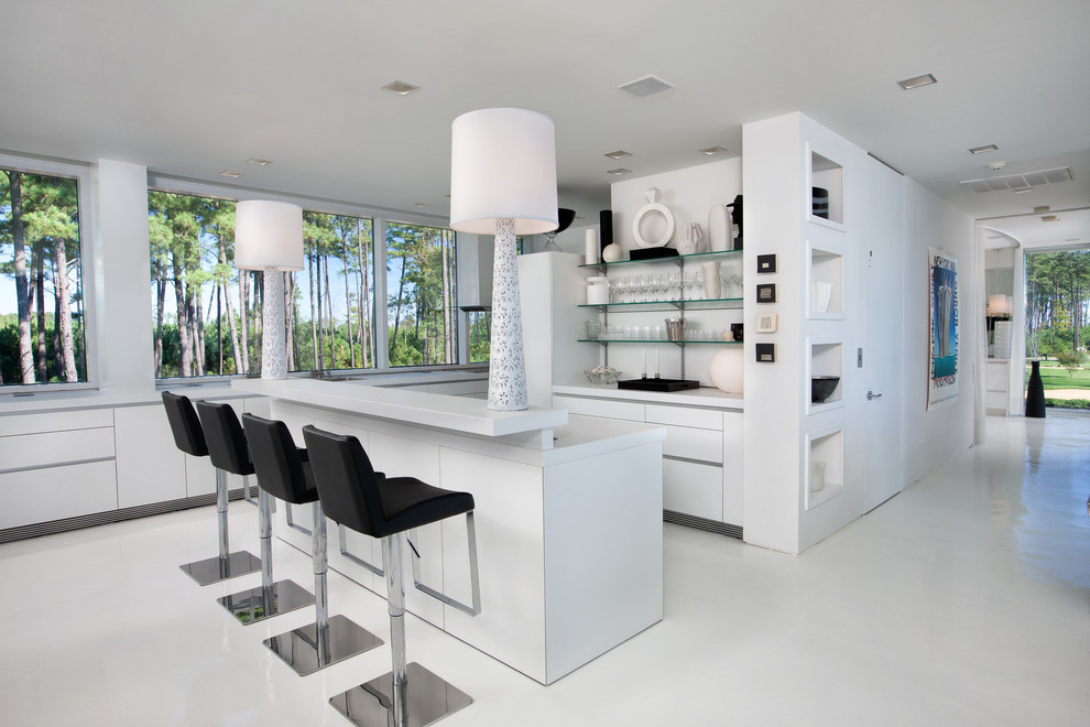 Inspiration for a medium sized contemporary kitchen/diner in Richmond with a double-bowl sink, flat-panel cabinets, white cabinets, laminate countertops, stainless steel appliances, concrete flooring and an island.