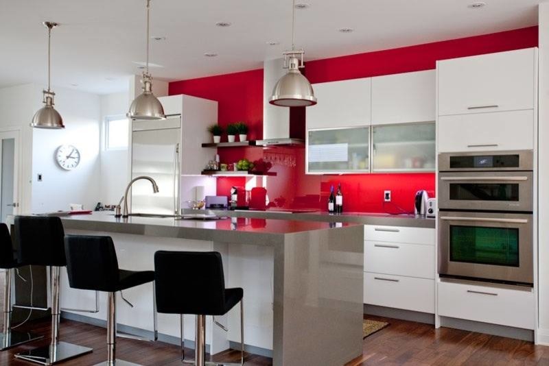 Inspiration för mellanstora moderna kök och matrum, med en dubbel diskho, vita skåp, rött stänkskydd, rostfria vitvaror, mellanmörkt trägolv och en köksö