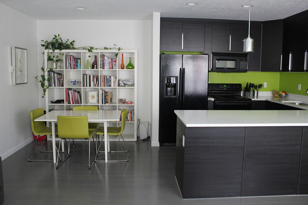 Modern inredning av ett litet kök, med en undermonterad diskho, släta luckor, svarta skåp, bänkskiva i koppar, grönt stänkskydd, svarta vitvaror, klinkergolv i porslin, en halv köksö och grått golv