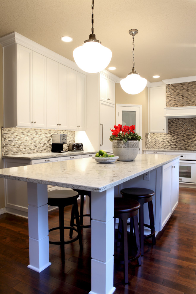 Example of a mid-sized trendy u-shaped medium tone wood floor open concept kitchen design in Portland with a farmhouse sink, white cabinets, marble countertops, multicolored backsplash, mosaic tile backsplash, white appliances and an island