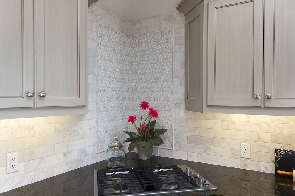 Exempel på ett stort klassiskt kök, med en enkel diskho, luckor med infälld panel, grå skåp, granitbänkskiva, vitt stänkskydd, stänkskydd i marmor, rostfria vitvaror, mellanmörkt trägolv, en köksö och brunt golv