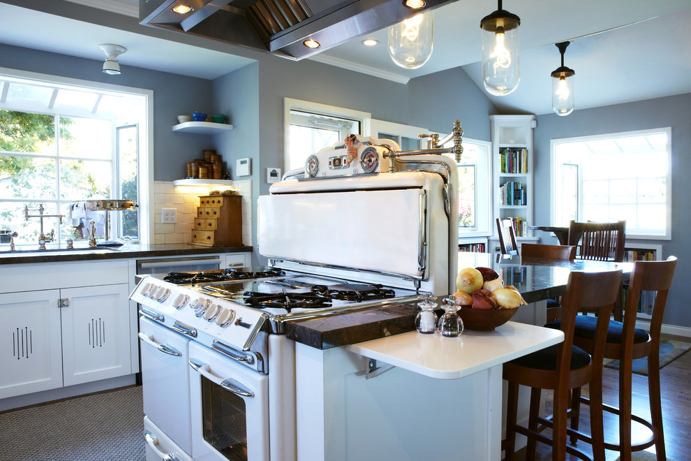 Foto di una grande cucina costiera con ante in stile shaker, ante bianche, paraspruzzi bianco, paraspruzzi con piastrelle diamantate, elettrodomestici in acciaio inossidabile e parquet chiaro
