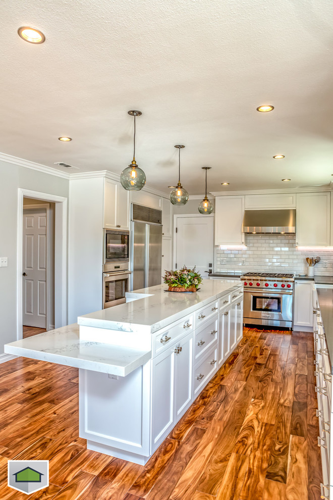Eat-in kitchen - large contemporary u-shaped medium tone wood floor eat-in kitchen idea in San Francisco with a farmhouse sink, shaker cabinets, white cabinets, marble countertops, white backsplash, subway tile backsplash, stainless steel appliances and an island
