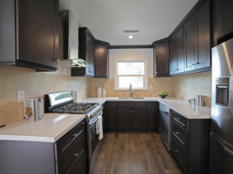 Exempel på ett mellanstort modernt vit vitt kök, med en dubbel diskho, skåp i shakerstil, skåp i mörkt trä, bänkskiva i kvartsit, beige stänkskydd, rostfria vitvaror, laminatgolv, brunt golv och stänkskydd i travertin