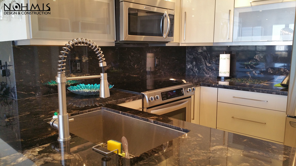 This is an example of a small contemporary galley kitchen/diner in Miami with a double-bowl sink, beaded cabinets, beige cabinets, granite worktops, beige splashback, ceramic splashback, stainless steel appliances, marble flooring and an island.