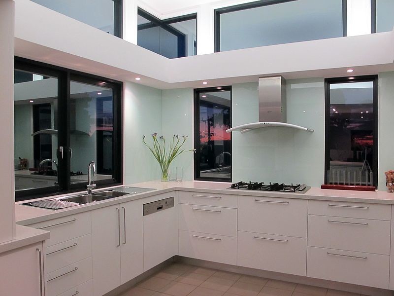 Свежая идея для дизайна: кухня среднего размера в стиле модернизм с обеденным столом, белыми фасадами, синим фартуком и фартуком из стекла - отличное фото интерьера