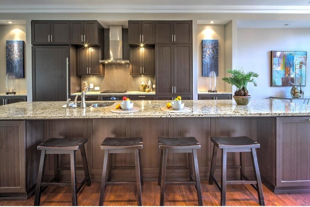 Inspiration for a medium sized contemporary galley kitchen in Atlanta with a double-bowl sink, raised-panel cabinets, dark wood cabinets, granite worktops, beige splashback, integrated appliances, medium hardwood flooring and an island.