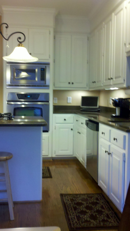Bild på ett litet vintage kök, med skåp i shakerstil, vita skåp, granitbänkskiva, rostfria vitvaror, mörkt trägolv och en köksö