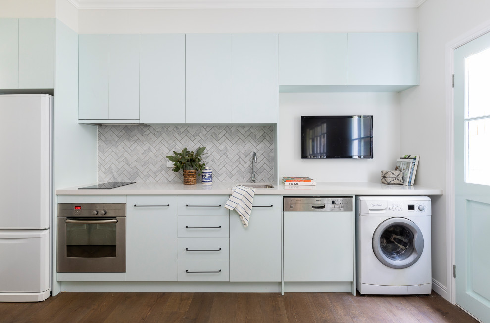 This is an example of a small contemporary single-wall kitchen in Brisbane with a submerged sink, engineered stone countertops, grey splashback, marble splashback, no island, flat-panel cabinets, blue cabinets, brown floors and grey worktops.