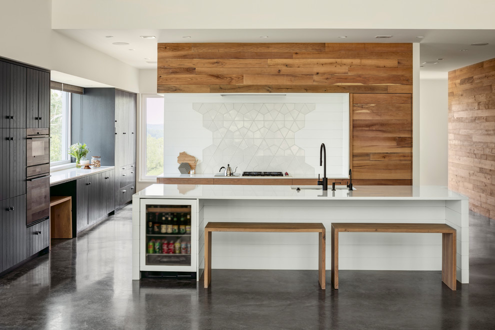 Esempio di una cucina minimalista con lavello sottopiano, ante lisce, ante in legno scuro, paraspruzzi bianco, elettrodomestici neri, pavimento in cemento, pavimento grigio e top bianco