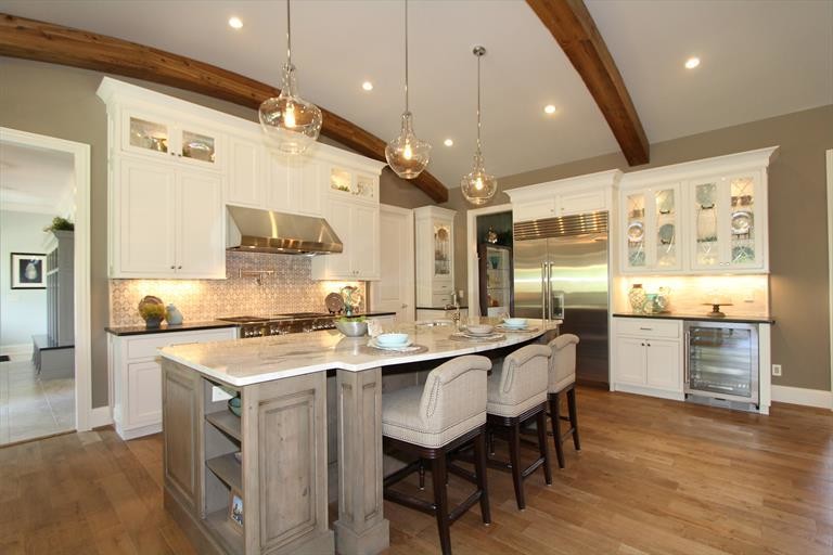 Inspiration for a large transitional medium tone wood floor eat-in kitchen remodel in Cincinnati with a farmhouse sink, gray cabinets, marble countertops, beige backsplash, ceramic backsplash, stainless steel appliances and an island
