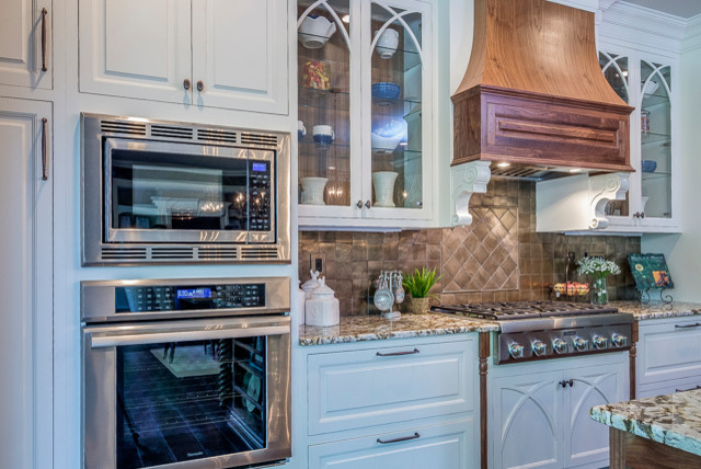 Exempel på ett mellanstort klassiskt linjärt kök med öppen planlösning, med en undermonterad diskho, luckor med upphöjd panel, vita skåp, granitbänkskiva, brunt stänkskydd, stänkskydd i stenkakel, rostfria vitvaror, mörkt trägolv och en köksö
