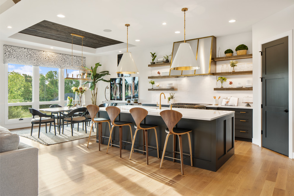 Design ideas for an expansive traditional open plan kitchen in Cincinnati with open cabinets, white splashback, light hardwood flooring, an island and white worktops.