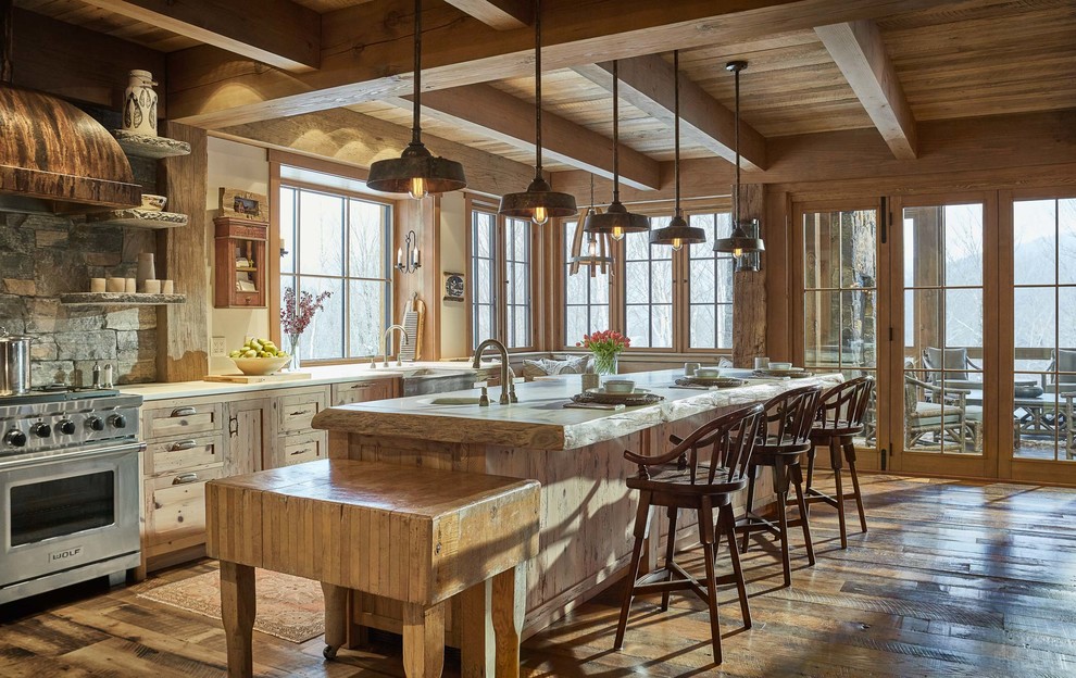 Foto på ett rustikt beige kök och matrum, med en rustik diskho, skåp i shakerstil, träbänkskiva, grått stänkskydd, stänkskydd i stenkakel, rostfria vitvaror, mellanmörkt trägolv, en köksö, brunt golv och skåp i ljust trä