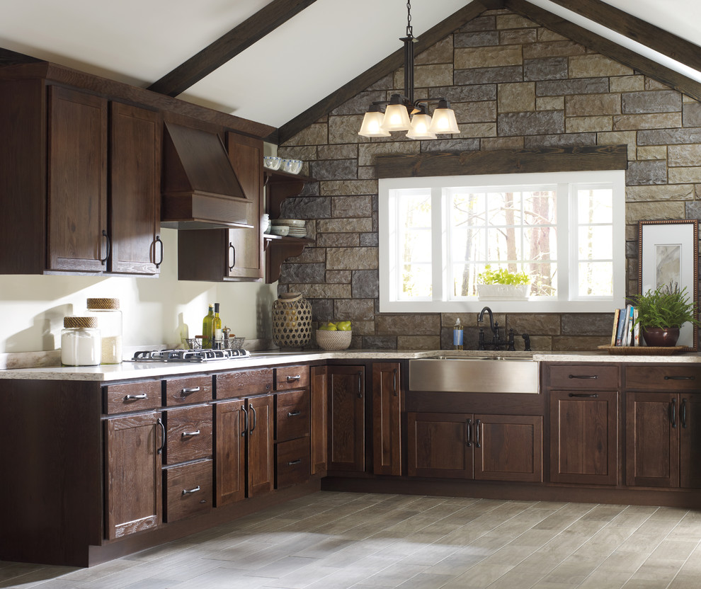 Inspiration for a large rustic l-shaped enclosed kitchen in Other with a belfast sink, shaker cabinets, dark wood cabinets, granite worktops, stainless steel appliances, laminate floors, no island and beige floors.