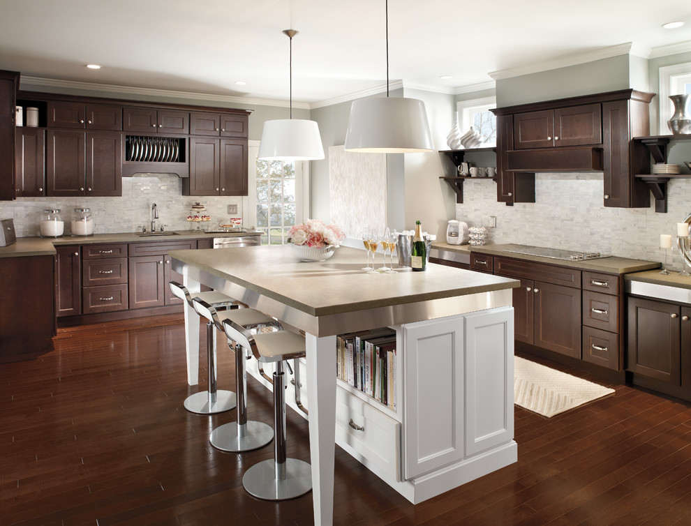 Traditional l-shaped kitchen in Chicago with an island, shaker cabinets, dark wood cabinets, white splashback, stainless steel appliances and dark hardwood flooring.