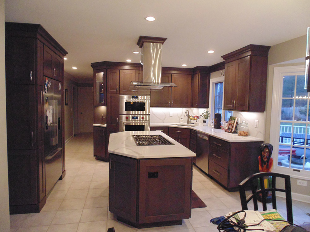 Mid-sized transitional u-shaped cement tile floor and beige floor eat-in kitchen photo in New York with an undermount sink, recessed-panel cabinets, dark wood cabinets, quartz countertops, beige backsplash, stainless steel appliances, an island and beige countertops