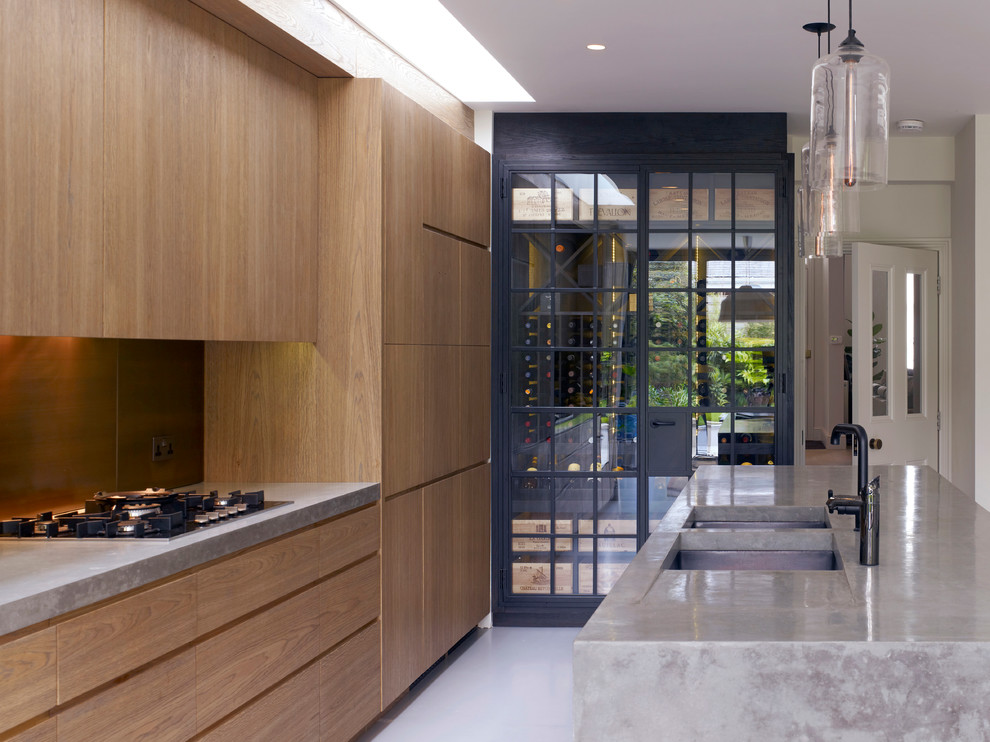 Aménagement d'une cuisine contemporaine en bois brun avec un évier encastré, un placard à porte plane, une crédence métallisée et une crédence en dalle métallique.