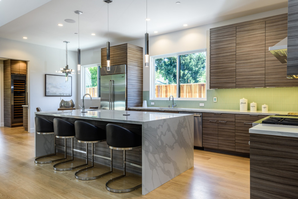 Design ideas for a large contemporary l-shaped kitchen/diner in San Francisco with a submerged sink, flat-panel cabinets, medium wood cabinets, green splashback, stainless steel appliances, an island, brown floors and grey worktops.