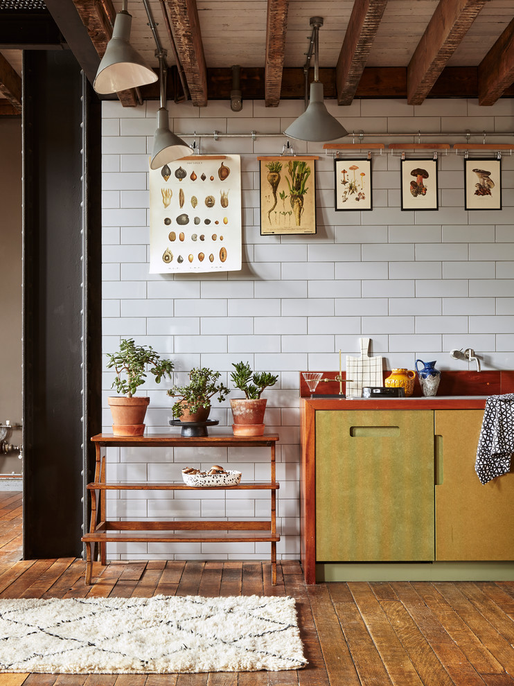 Industrial Küche mit Arbeitsplatte aus Holz, Küchenrückwand in Weiß, flächenbündigen Schrankfronten, Rückwand aus Metrofliesen und braunem Holzboden in London