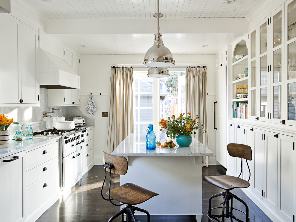 Foto de cocina clásica cerrada con puertas de armario blancas, salpicadero blanco, salpicadero de losas de piedra, electrodomésticos con paneles y barras de cocina