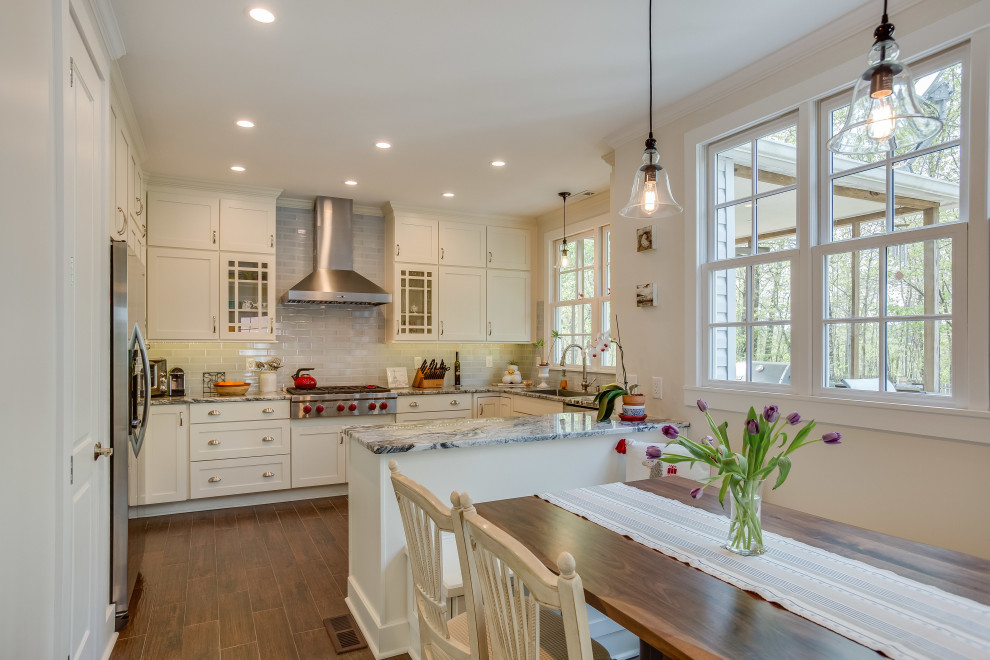 Eat-in kitchen - mid-sized transitional u-shaped eat-in kitchen idea in Birmingham with shaker cabinets, white cabinets, granite countertops, gray backsplash, subway tile backsplash, stainless steel appliances, a peninsula and white countertops