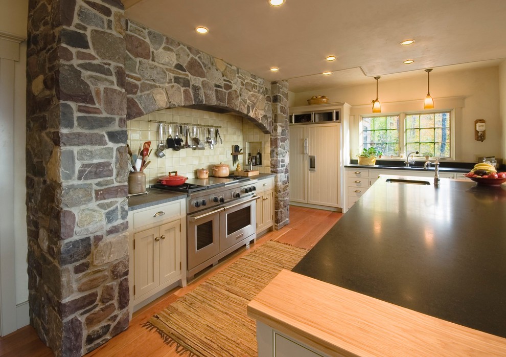 Kitchen pantry - large traditional u-shaped kitchen pantry idea in Burlington with an undermount sink, recessed-panel cabinets, granite countertops, stainless steel appliances, an island and black countertops