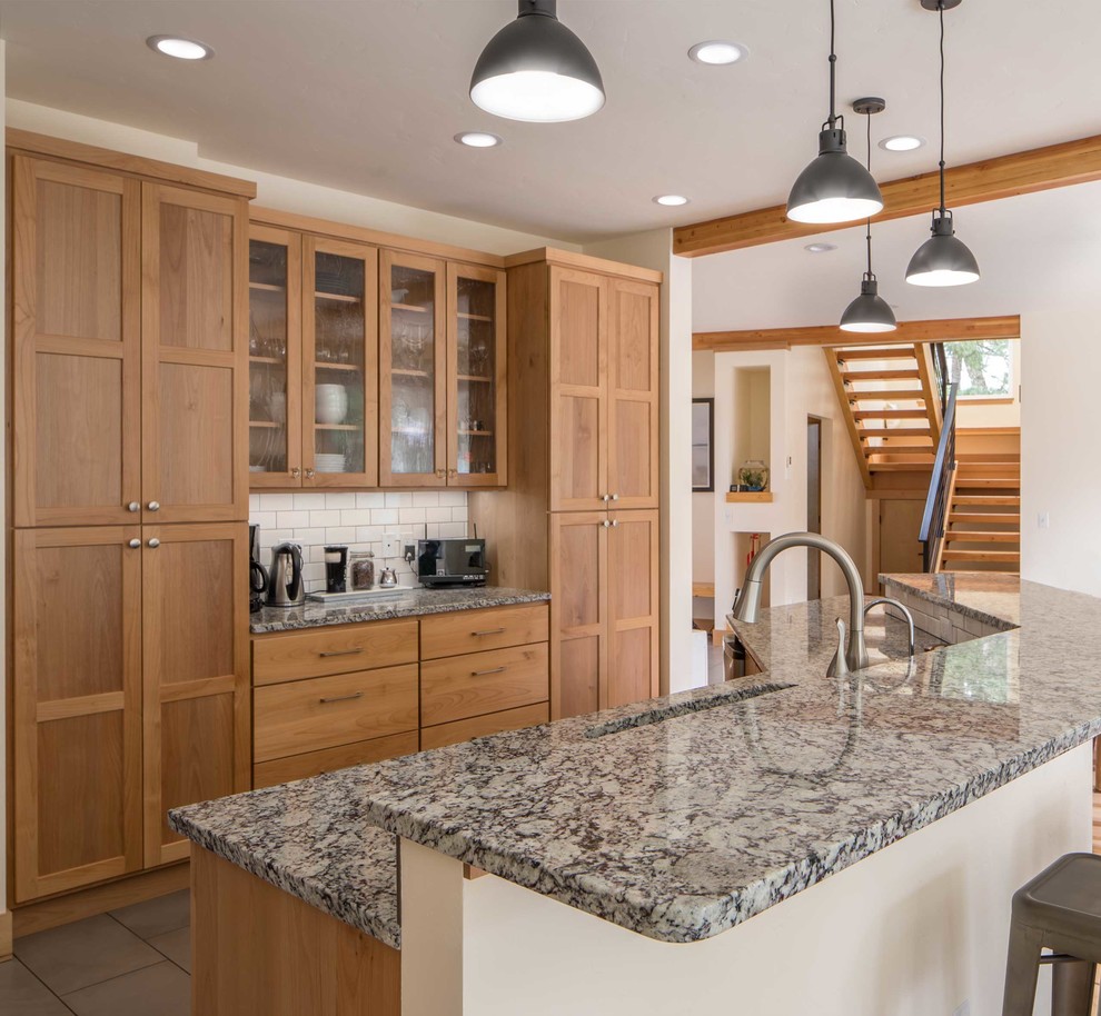 Mid-sized trendy ceramic tile and gray floor open concept kitchen photo in Portland with an undermount sink, shaker cabinets, medium tone wood cabinets, granite countertops, white backsplash, subway tile backsplash, stainless steel appliances, an island and gray countertops