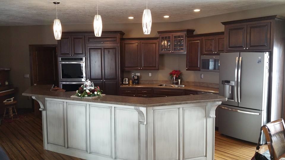 Bild på ett mellanstort rustikt kök och matrum, med en undermonterad diskho, luckor med upphöjd panel, skåp i slitet trä, laminatbänkskiva, rostfria vitvaror, mellanmörkt trägolv och en köksö