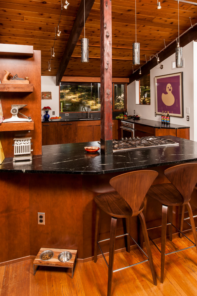 ローリーにある高級な中くらいなコンテンポラリースタイルのおしゃれなキッチン (ダブルシンク、フラットパネル扉のキャビネット、中間色木目調キャビネット、ソープストーンカウンター、シルバーの調理設備、コルクフローリング) の写真