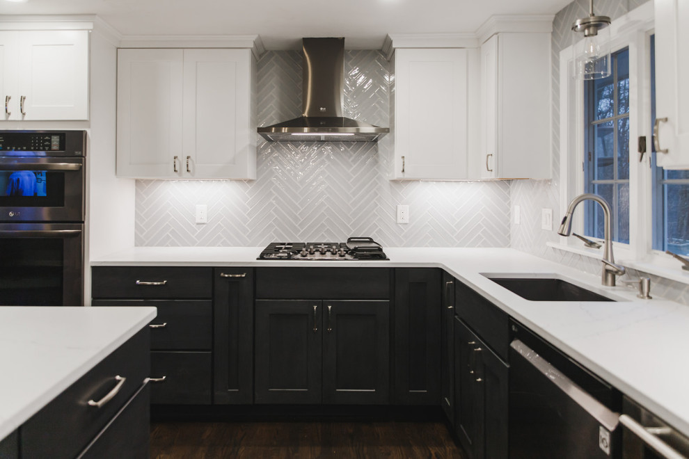 Modern inredning av ett mellanstort vit vitt kök, med skåp i shakerstil, svarta skåp, marmorbänkskiva, grått stänkskydd, stänkskydd i keramik, rostfria vitvaror, mörkt trägolv, en köksö och brunt golv