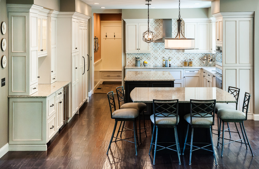 Kitchen pantry - mid-sized traditional l-shaped dark wood floor and brown floor kitchen pantry idea in Boston with an undermount sink, beaded inset cabinets, white cabinets, granite countertops, multicolored backsplash, ceramic backsplash, stainless steel appliances and two islands