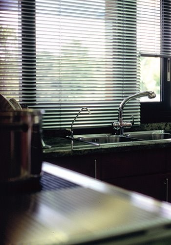 This is an example of a small contemporary l-shaped kitchen/diner in Miami with a double-bowl sink, stainless steel worktops, stainless steel appliances and no island.