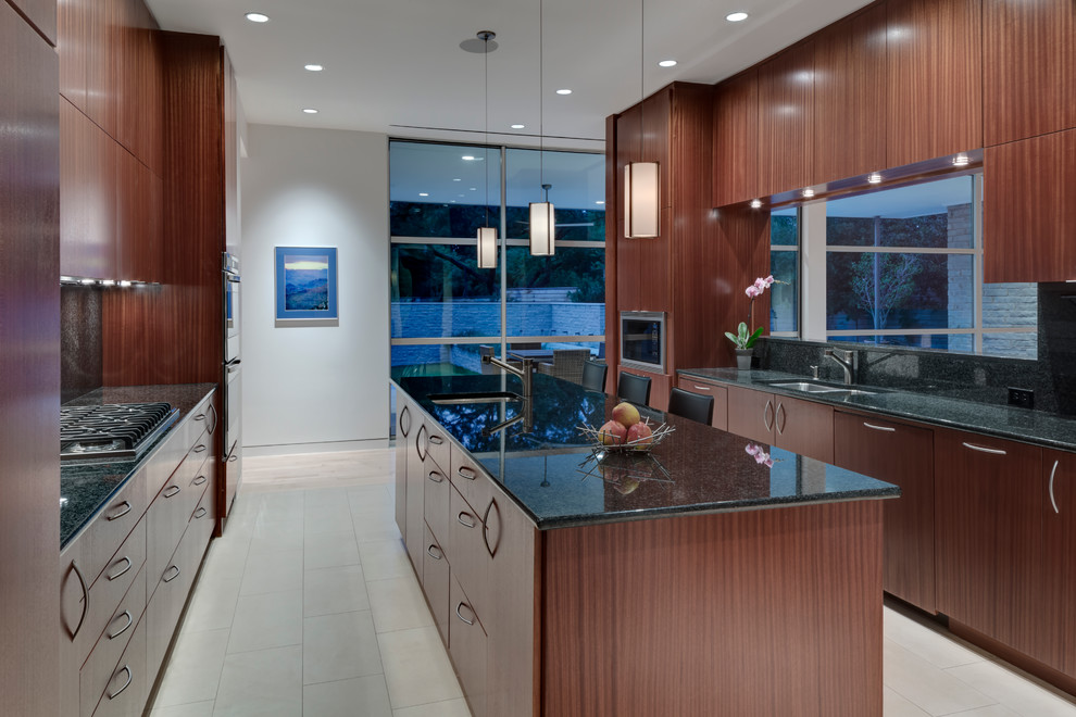 Kitchen - modern u-shaped kitchen idea in Dallas with flat-panel cabinets, medium tone wood cabinets, granite countertops, green backsplash, stone slab backsplash and stainless steel appliances