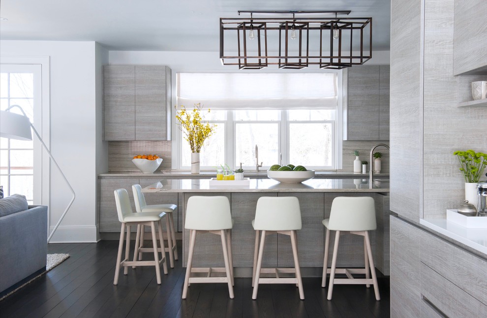 This is an example of an expansive modern u-shaped open plan kitchen in New York with a submerged sink, flat-panel cabinets, grey cabinets, granite worktops, grey splashback, stainless steel appliances, dark hardwood flooring, an island, stone slab splashback and grey floors.