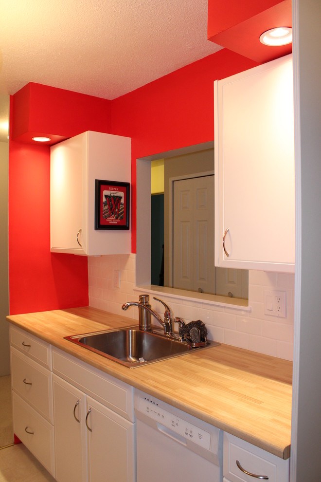 Example of a small trendy galley vinyl floor enclosed kitchen design in Other with a drop-in sink, raised-panel cabinets, white cabinets, laminate countertops, white backsplash, subway tile backsplash, white appliances and no island