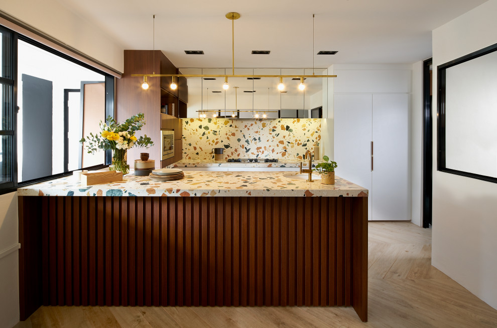 1960s u-shaped light wood floor and beige floor kitchen photo in Singapore with an undermount sink, flat-panel cabinets, white cabinets, terrazzo countertops, multicolored backsplash, a peninsula and multicolored countertops