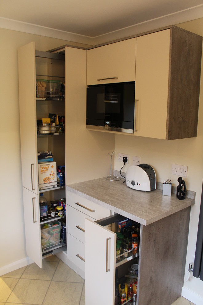 Foto på ett mellanstort funkis kök, med en integrerad diskho, släta luckor, beige skåp, laminatbänkskiva och integrerade vitvaror